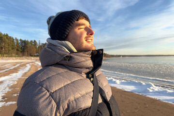 Side portrait of handsome young man, happy guy breathing deep deeply, inhale fresh frosty air at...