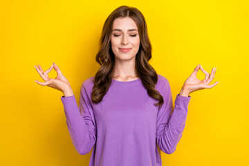 Photo of young attractive chilling woman closed eyes wear purple pullover balance asana meditation after work isolated on yellow color background