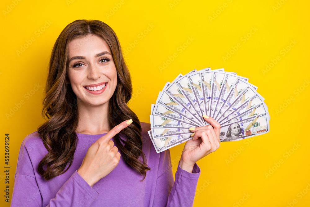 Sticker Photo of pretty shiny lady wear violet sweater pointing finger usd cash fan empty space isolated yellow color background