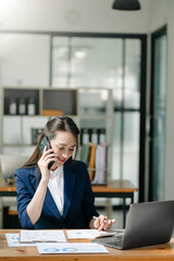 Happy asian business woman have the joy of talking on the smartphone, tablet and laptopon the office .