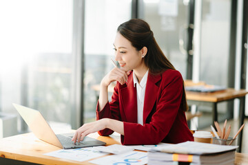 Young beautiful woman using laptop and tablet while sitting at her working place. Concentrated at work...