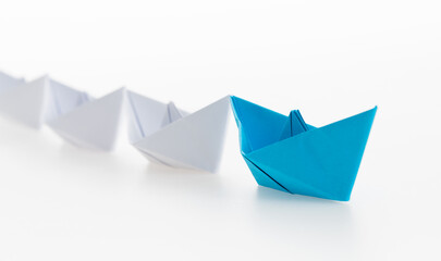 The blue origami boat is leader