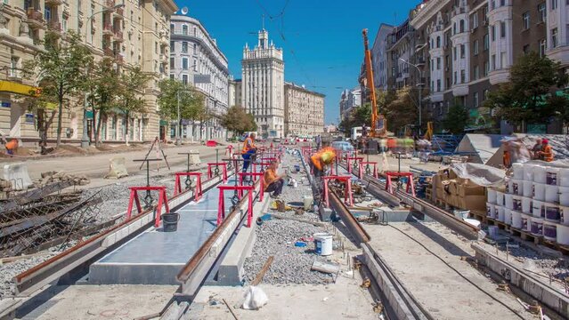 Tram rails at the final stage of their installation and integration into concrete plates on the road timelapse with crane. Filling by liquid resin for reduction of vibration and noice. The process of