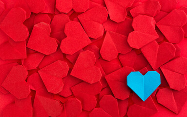 Blue origami heart on red origami hearts