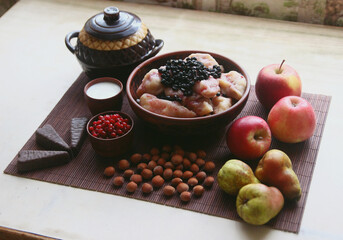Ukrainian dumplings with blueberries. Still life with apples, candies, nuts.