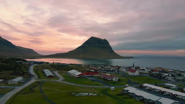 The famous and large Kirkjufell mountain in Iceland at sunset with a fishing village by the sea #2.
