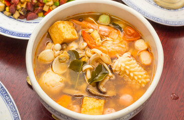 Bowl of chinese soup with vegetables, shrimp and squid