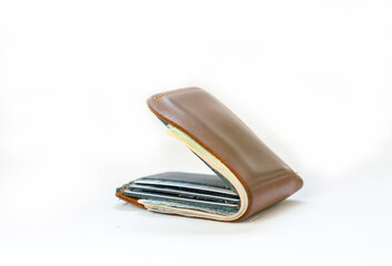 Dollar bills and credit card in brown leather wallet.