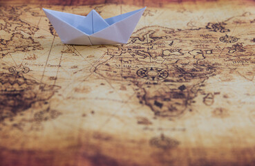 White origami boat on world map background
