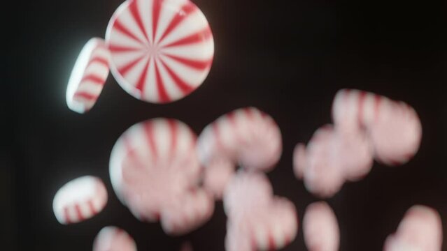 Peppermint candies falls in slow motion, black background 