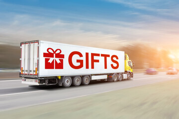 Trailer truck with container with symbol of gifts inscription rushes along winter road with a...