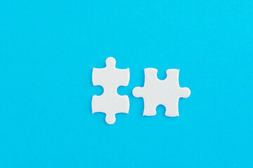 Obraz premium Two puzzle pieces on blue background