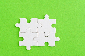 Four puzzle pieces on green background
