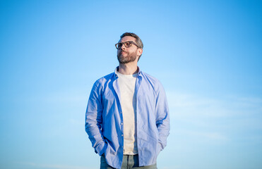 pensive caucasian man look peaceful. pensive man in glasses outdoor. pensive man on sky background.