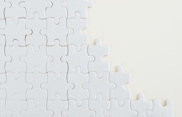 Unfinished white puzzle pieces on white background