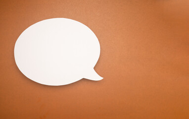 A blank white speech bubble on a brown background