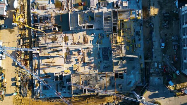 4K hyperlapse time-lapse of under construction site, crane, and car traffic transportation at night in city downtown. Drone aerial top view. Industrial business or civil engineering technology concept
