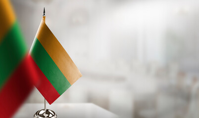 Small flags of the Lithuania on an abstract blurry background - obrazy, fototapety, plakaty