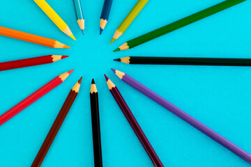 Color pencils make a circle on blue background