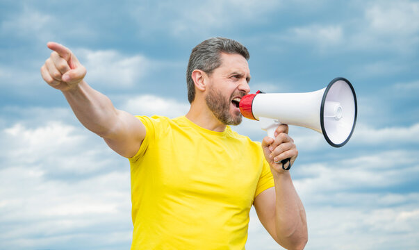 man in yellow shirt shout in megaphone on sky background. discount