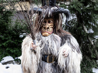 Portrait of a boy in a krampus costume, animal skin, horns and a wooden mask, Austria, Salzburg