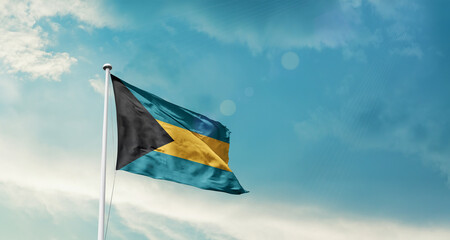 Waving Flag of the bahamas in Blue Sky. The symbol of the state on wavy cotton fabric.