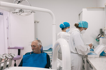 Patient waiting in the dental clinic, two nurses preparing for the procedure