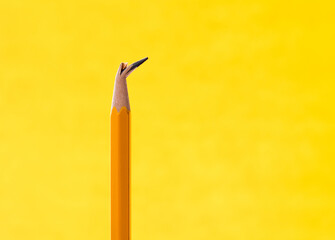 Broken pencil tip on yellow background