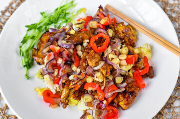 Rosted chicken piece with red pepper, chilli, onion, garlic with soy sauce on rice, chopstick