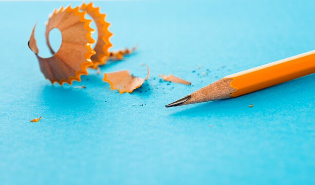 Pencil and pencil shavings on blue background