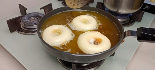 assorted donuts with chocolate frosted, pink glazed and sprinkles donuts. Donuts in hand or tray