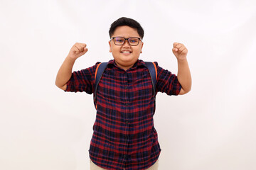 Successful asian school boy standing with clenched hands. Isolated on white background