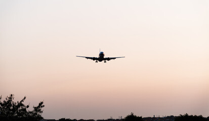 Fototapeta na wymiar Background of airplane landing at sunset