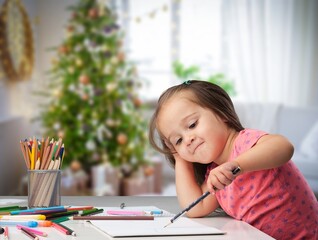 Little child drawing in christmas room. New year concept.