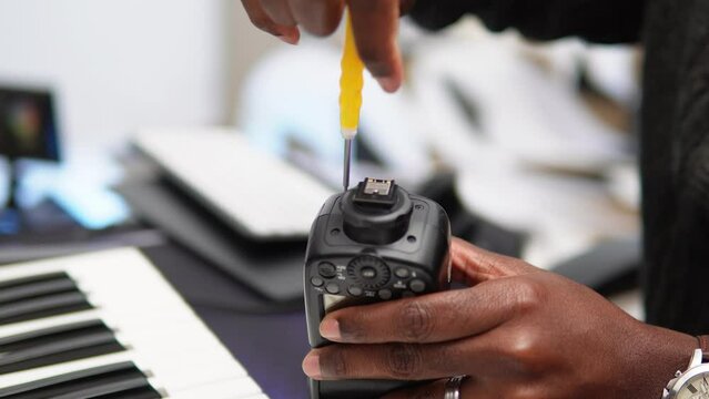 Man closing the camera flash with a screwdriver.
