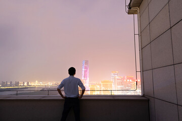 Businessman standing on the rooftop and looking away