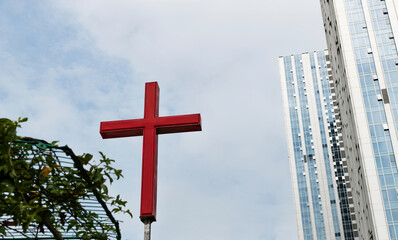 A cross next to the skyscraper in the city