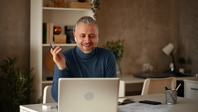 Middle aged businessman having an video call while working from home