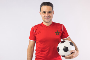 Man wearing the red jersey of Morocco holding a soccer ball. Sport, world cup.
