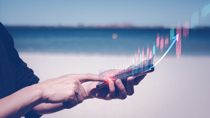 planning and strategy, Stock market, Business growth, progress or success concept. Businessman is trading with smartphone on blurred beach background.trading everywhere concept.