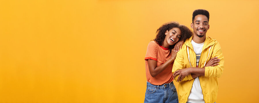 Awesome When Boyfriend Is Best Friend. Portrait Of Charming Friendly African American Woman Leaning On Guy Touching His Shoulder Feeling Happy They Together And She Can Rely On Posing Orange Wall