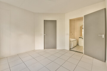 an empty room with tile flooring and door leading to another room in the same area, there is a...