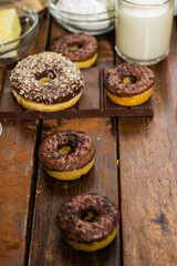 Preparing doughnuts at home. Ingredients for donuts such as eggs, milk, chocolate, pudding, butter, cacao, flour, rolling pin, cake pan, grater, egg beater, spatula