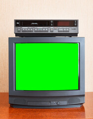 Old vintage TV with green screen to add new images to the screen, VCR on wallpaper background.