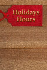 Fototapeta na wymiar Holiday Hours message on red gift tag with space for your hours