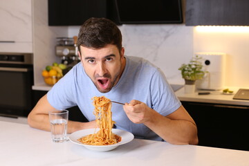 Fototapeta na wymiar Man enjoying a plate of spaghetti with tomato sauce 