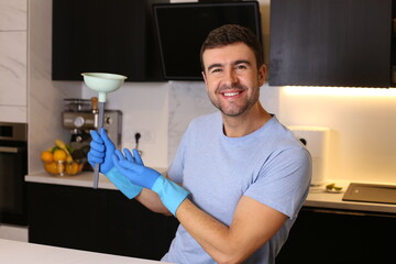 Man holding a plunger in his kitchen 