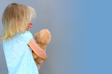 little child, blonde girl 3 years old plays with toy, hugs teddy bear, happy childhood, first...