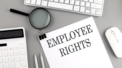 EMPLOYEE RIGHTS written on paper with office tools and keyboard on the grey background - obrazy, fototapety, plakaty