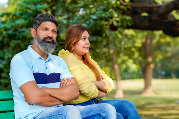 Indian couple giving angry expression at park.